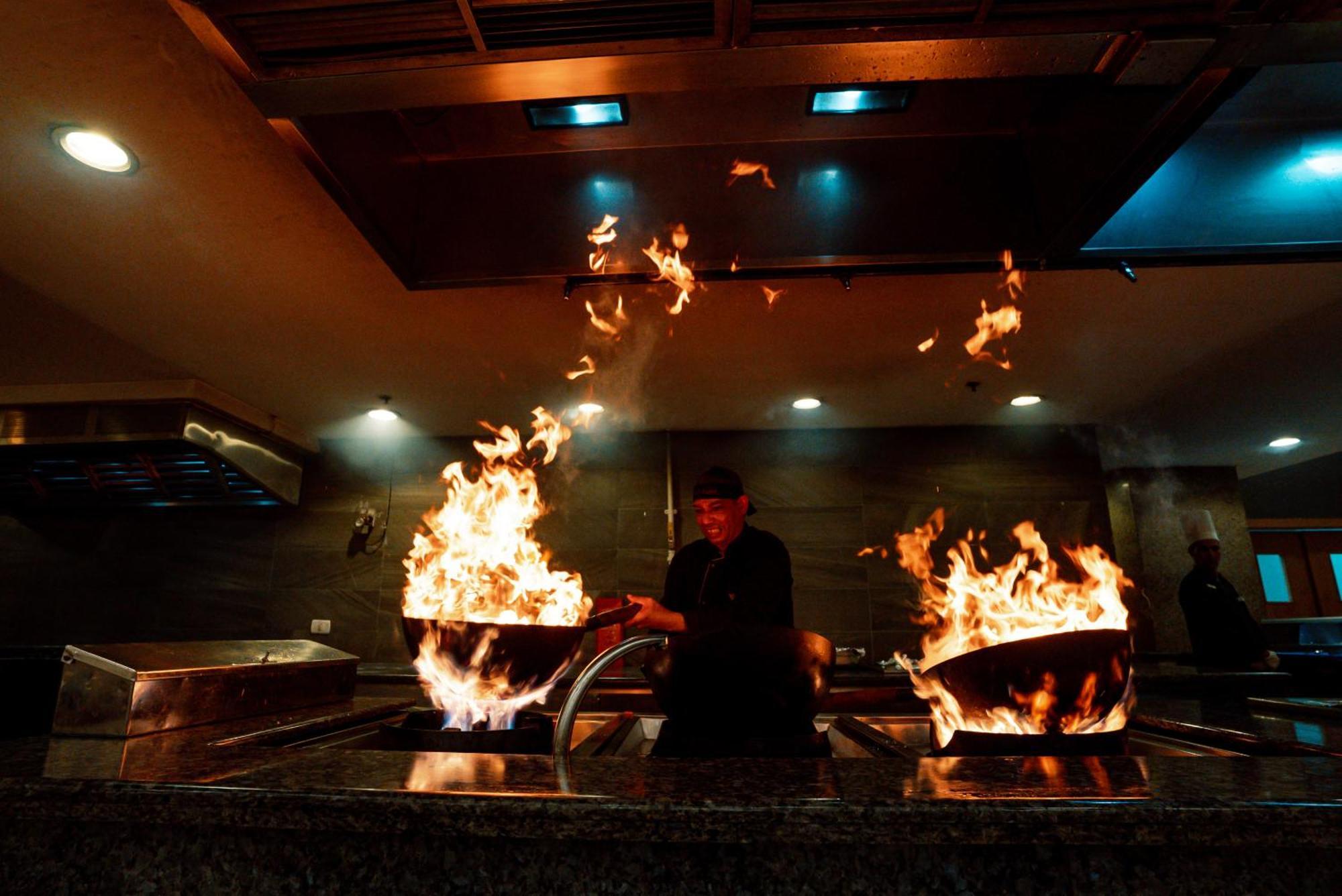 The V Luxury Resort Sahl Hasheesh Hurghada Esterno foto A chef cooking with a wok
