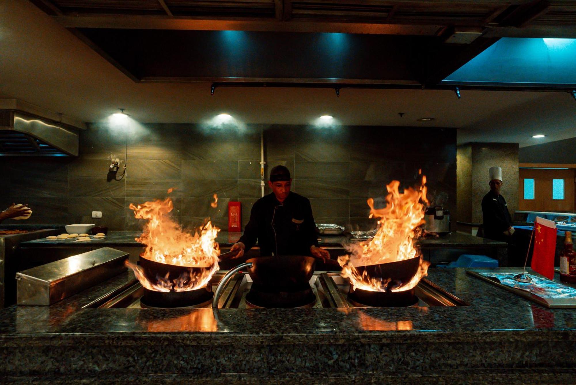 The V Luxury Resort Sahl Hasheesh Hurghada Esterno foto A chef cooking with a wok