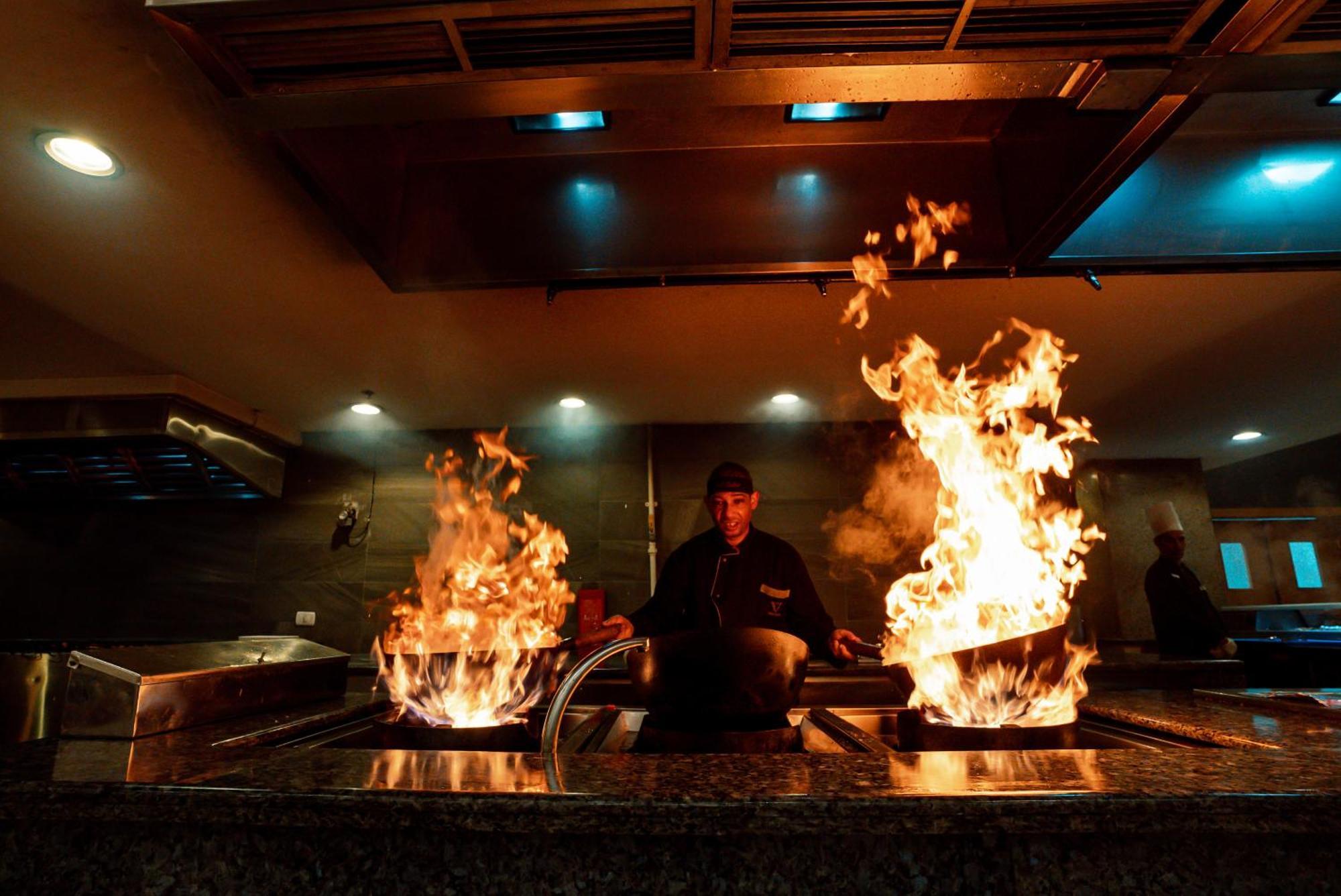 The V Luxury Resort Sahl Hasheesh Hurghada Esterno foto A chef cooking with a wok